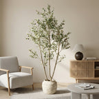 Faux olive tree in a living room, shown in a stone planter that is not included