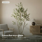 Faux olive tree in a living room beside an armchair, shown in a stone planter that is not included