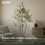 Faux olive tree in a living room beside an armchair, shown in a stone planter that is not included